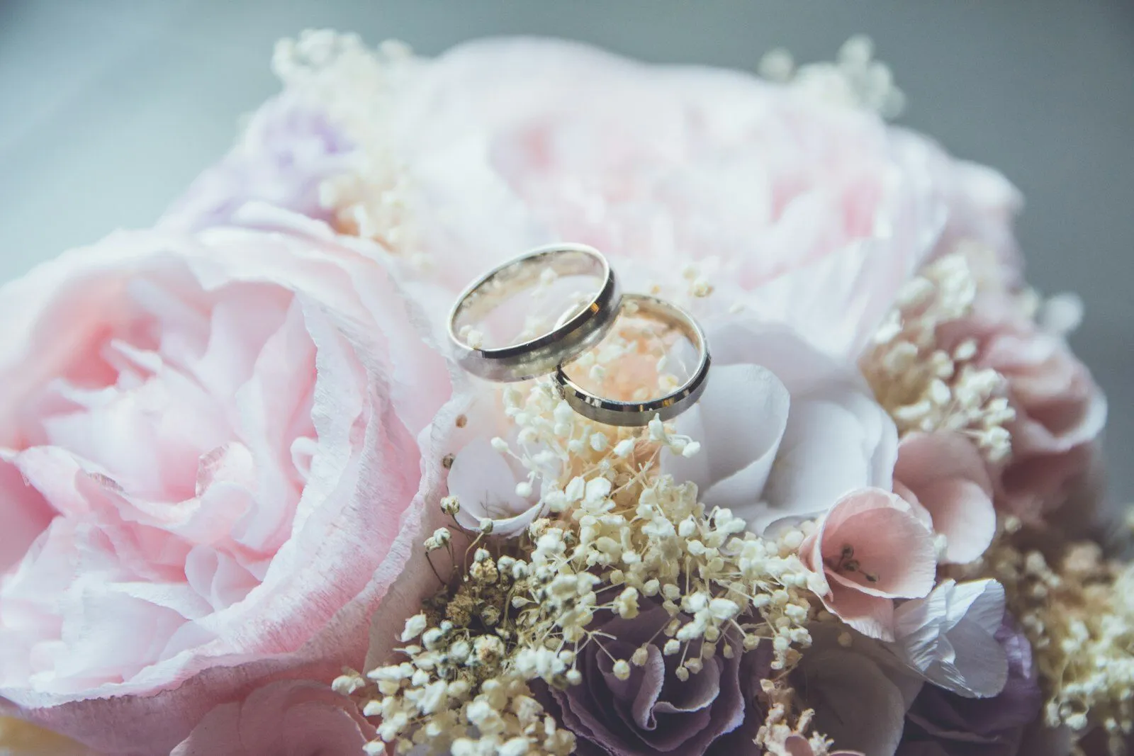 Anillos de boda sobre un libro con flores
